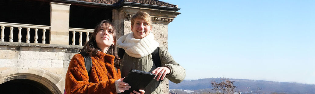 Zwei Frauen mit iPad vor dem Schlossportal